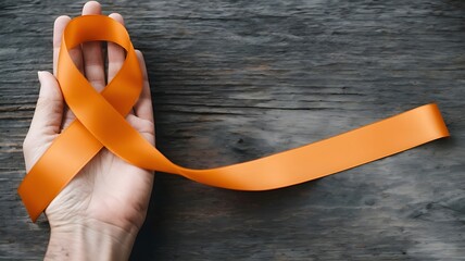 Orange ribbon on old wood background raising awareness on leukemia, kidney cancer, RSD multiple sclerosis Satin fabric color symbolic concept for public support on people living with tumor disease