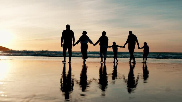 Rear view, holding hands and silhouette of family walking on beach together for travel, holiday or vacation. Kids, parents and grandparents by water or sea for love, adventure or bonding at sunset