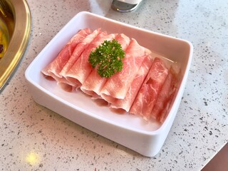 Sliced duck meat in white ceramic dish for hotpot. Selective focus