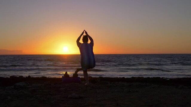 Practicing yoga at the sunset in 4k slow motion 60fps