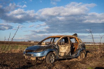 burned car wreck near to highway - 717639542