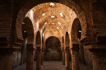 Interior of Arab Baths (Banos Arabes), Ronda, Andalucia, Spain. It is a unique archeological site showcasing a 13th-century bathhouse that was built during the Islamic period in Ronda. - obrazy, fototapety, plakaty