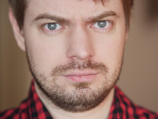 Fototapeta premium Sad young man, portrait on the beige background.