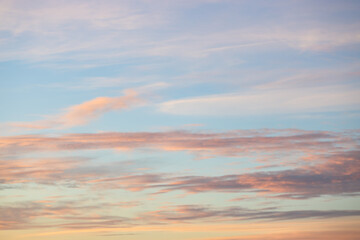 A beautiful sky tinted by the sun leaving vibrant shades of gold, pink, blue and multicolored. Clouds in the twilight evening and morning sky. Cloudy sky background in the evening and during the day.