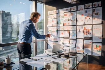 Fotobehang Businessman Analyzing Project on Office Wall Boards.  A focused businessman reviews complex project plans displayed on wall-mounted boards in a well-lit modern office. generative ai © somchairakin