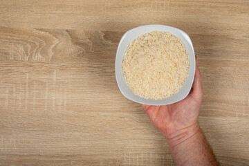 Hand Holding White Rice Bowl - Hunger, Food and Agricultural Greenhouse Gas Emissions Concept