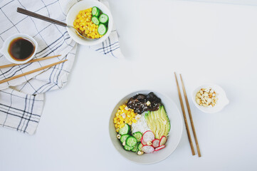 tasty vegetarian diet dinner - asian style buddha bowl with rice, avocado, cucumber, corn, woody...