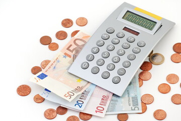 Euro coins on paper euro banknotes and calculator.  - 717670983