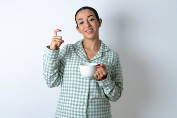 Beautiful young woman wearing green plaid pyjama pointing up with fingers number nine in Chinese sign language Jiu