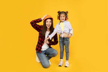 Mother and daughter in accessories for construction, on a yellow background.