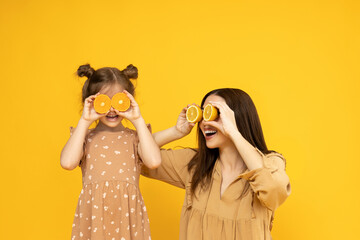 Mother and daughter are playing, on a yellow background.