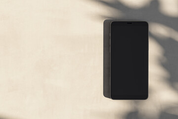 Close up of empty cellphone on light surface with leaf shadows. Presentation concept. Mock up, 3D Rendering.