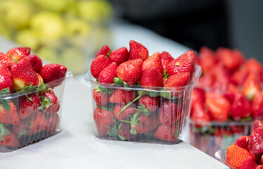 fresh strawberries in plastic boxes at the city market - 717684599