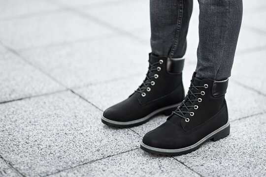 Isolated outdoor street photo of a generic pair of boots. Walk the city streets in style with these rugged yet fashionable brown boots that perfectly complement a pair of slim-fit jeans.