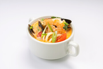 Business lunch. Tom yam soup with shrimp and mussels in a white bowl on a white background