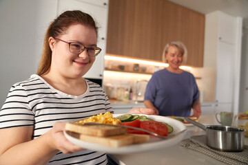 Down syndrome woman serving breakfast