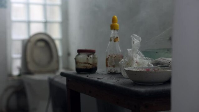 Film of long abandoned house - creepy - bathroom and table with misty smoke in the frame with toilet in the background