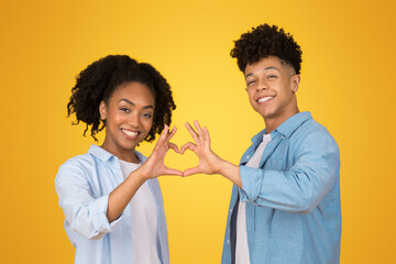 Affectionate young African American couple forming a heart shape with their hands together