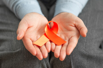 Woman's hands holding satin ribbon. Healthcare and cancer awareness concept.