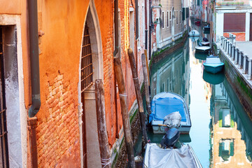 Narrow water canal with boats in Venice