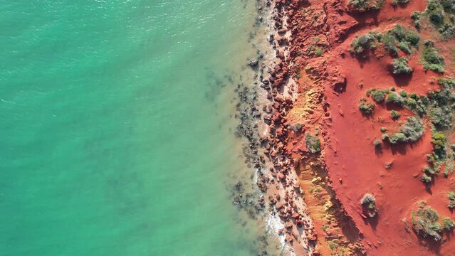 Video of Francois Peron National Park view from the sky. Aerial video of orange sand, crystal clear water, rocky beach in Shark Bay, Western Australia. 90 degrees angle with a drone.