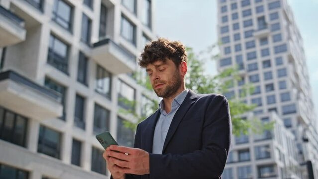 Joyful businessman answering call in city street closeup. Confident guy walking