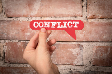 Conflict. Red speech bubble with text on a red brick background