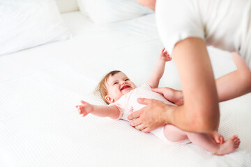 Six month baby on bed playing with father