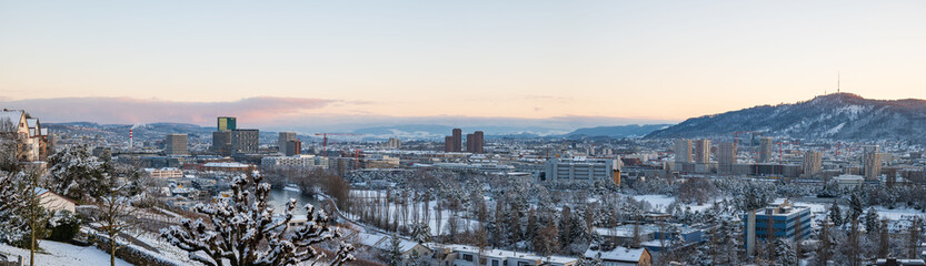 Snow covered Zurich or Zürich city. Top view panorama, rooftop POV, sunset sky, no people
