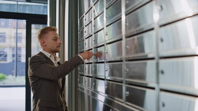 Smiling guy check correspondence in corridor closeup. Handsome man walk in suit