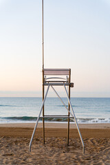 vertical image in the morning at dawn of a lifeguard surveillance post with no one sitting and with...