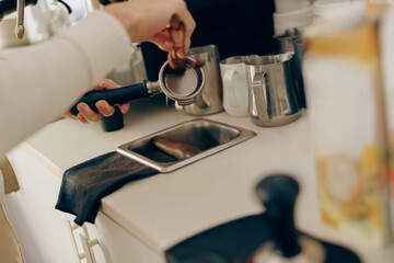 Close up of barista is cleaning and drying a filter holder after using. High quality photo