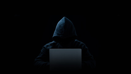 Hacker in a hood on a dark background, IT specialist.Copy space. Concept of Data thief, internet...