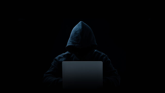 Hacker in a hood on a dark background, IT specialist.Copy space. Concept of Data thief, internet fraud, darknet and cyber security.