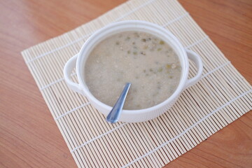 Mung Bean Porridge or Bubur Kacang Hijau, Indonesian dessert porridge of mung beans with coconut milk, pandan leaf and ginger. Served in bowl.