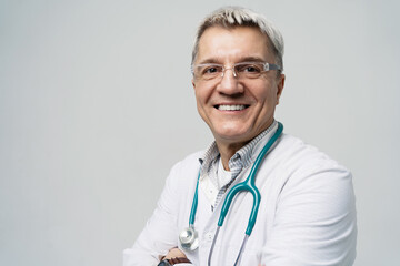 Smiling mature doctor with stethoscope portraying trust and professionalism in healthcare.