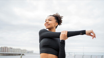 Woman stretching post-run, with a satisfied look towards the city skyline.