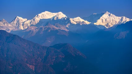 Fotobehang Kangchenjunga A view of Snow clad Kangchenjunga, also spelled Kanchenjunga, is the third highest mountain in the world. It lies between Nepal and Sikkim, India,