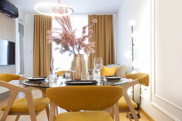 Dining table in the kitchen with pink flowers bouquet in the vase	