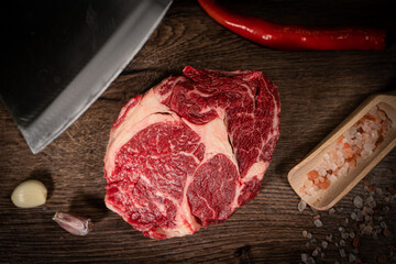 Organic machete or hanger butcher steak, near butcher knife with pink pepper and rosemary. Black...