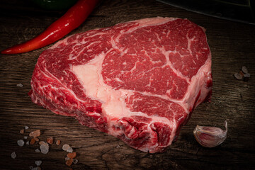 Raw hanging tender or onglet steak of beef on wooden Board with rosemary and thyme on wooden background
