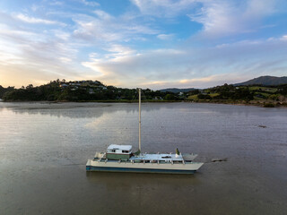 Fototapeta premium boat resting on mudflats at low tide in the Coromandel, Coromandel Peninsula, New Zealand.