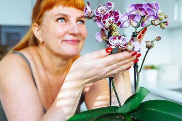 Woman takes care blooming orchid