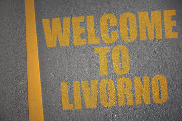 asphalt road with text welcome to Livorno near yellow line.