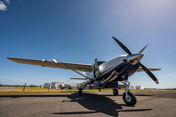 Fototapeta premium Light aircraft parked on tarmac wide angle