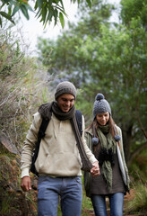 Couple, happy and hiking in forest or holding hands with travel, adventure and nature for wellness or fitness. Man, woman and trekking in woods for cardio, exercise or workout with view or backpack