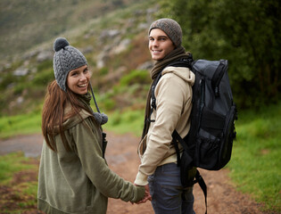 Happy couple, hiking on mountains and holding hands for outdoor adventure, travel journey and portrait. Young man and woman with love, eco friendly date and walking or trekking in backpack for winter