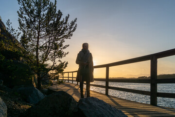 Blonde girl on the deck in sunset in mariehamn in aland islands