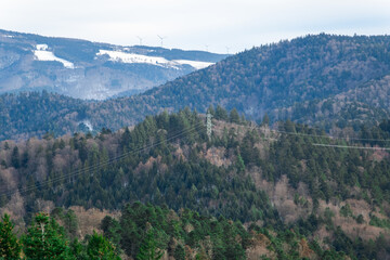 high voltage electric line in the winter forest in mountains