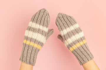 A pair of knitted mittens on the hands
